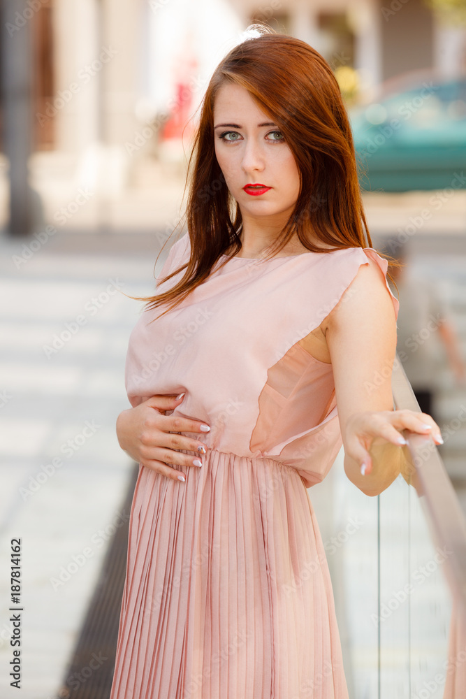 Woman in long dress walking on city street Woman in long dress walking on city street