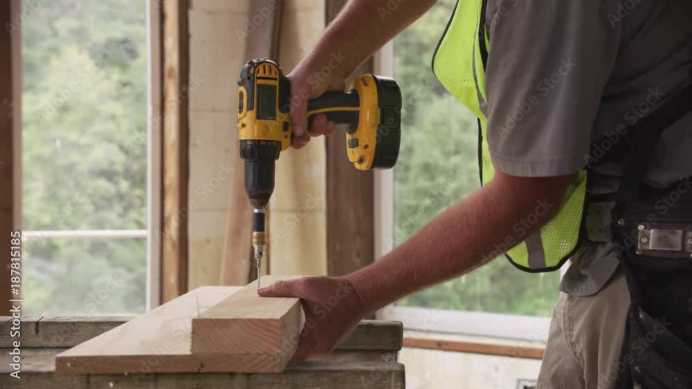 Construction worker using cordless screw gun