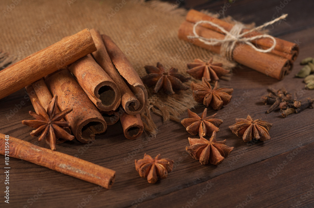 Cinnamon sticks and anise on sackcloth on a wooden background Cinnamon sticks and anise on sackcloth on a wooden background