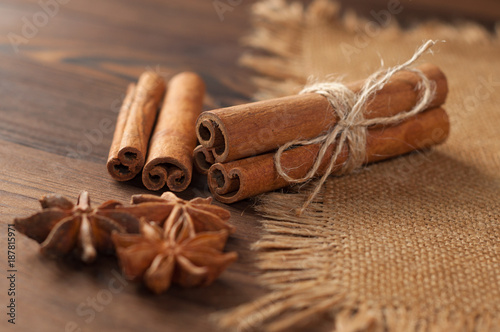 Cinnamon sticks and anise on sackcloth on a wooden background