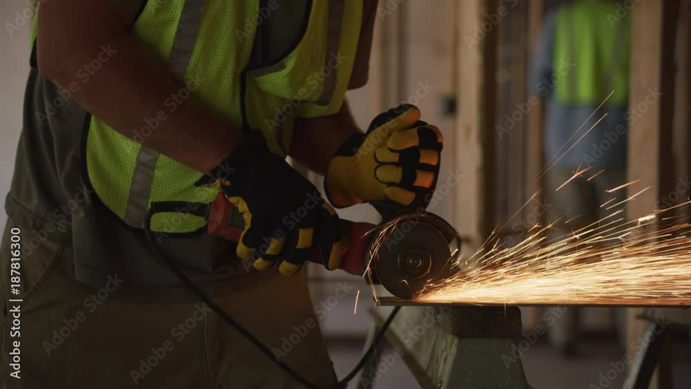 Construction worker grinding metal and making sparks