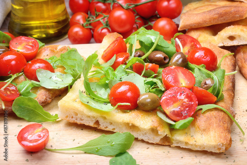 Focaccia with cherry tomatoes, arugula, olives and extra virgin olive oil