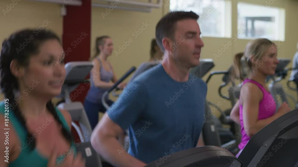 People running on treadmills at gym People running on treadmills at gym