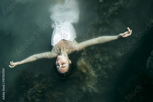 Caucasian woman wearing dress floating in water