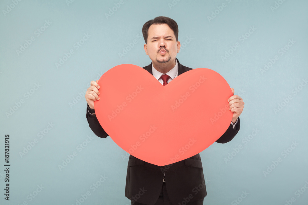 Funny businessman holding big red heart and send kiss Funny businessman holding big red heart and send kiss