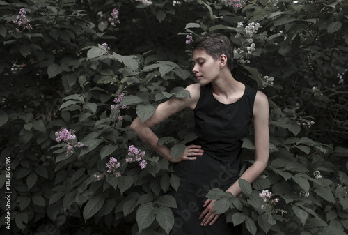 Caucasian woman near flowering tree with hand on hip photo