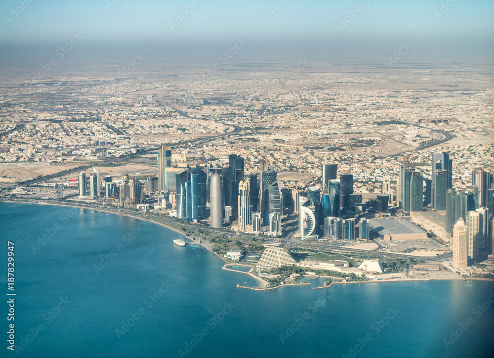 DOHA, QUATAR - DECEMBER 12, 2016: City aerial skyline from the airplane. Doha is a major hub for eastern travels