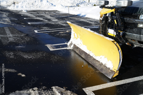 Snowplow in the parking lots with snow removed