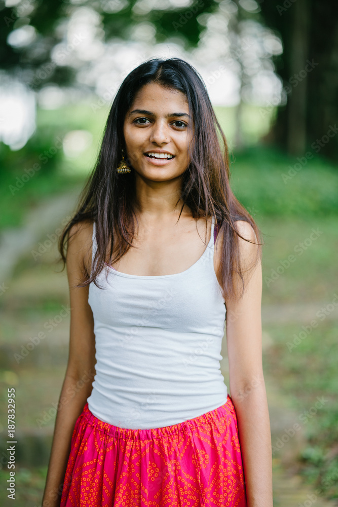 Candid portrait of a young and attractive Indian Asian woman in a lush,  green park (Fort