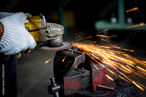 worker using grinder in workshop