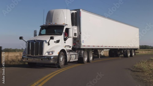 Semi truck driving on rural road.  Fully released for commercial use.