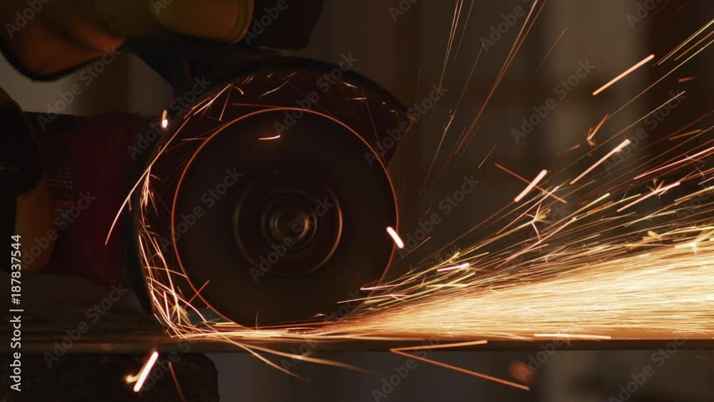 Construction worker grinding metal and making sparks, closeup