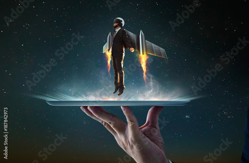 Waiter hand holding an empty digital tablet with Businessman wear a rocket suit to lift , Business success concept . photo
