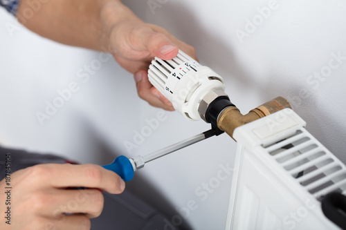 Bild auf Leinwand Male Plumber Fixing Thermostat