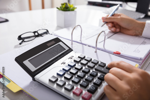 Businessperson Calculating Bills In Office