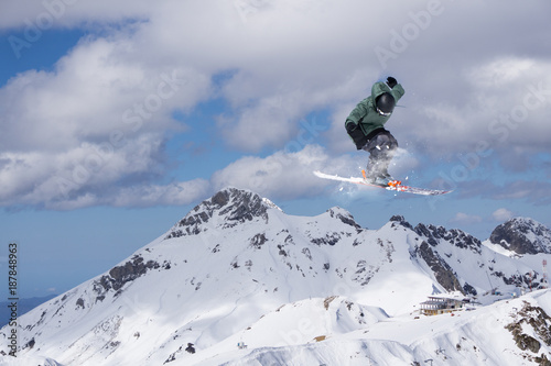 Skier jump in the mountains. Extreme ski sport. Freeride.