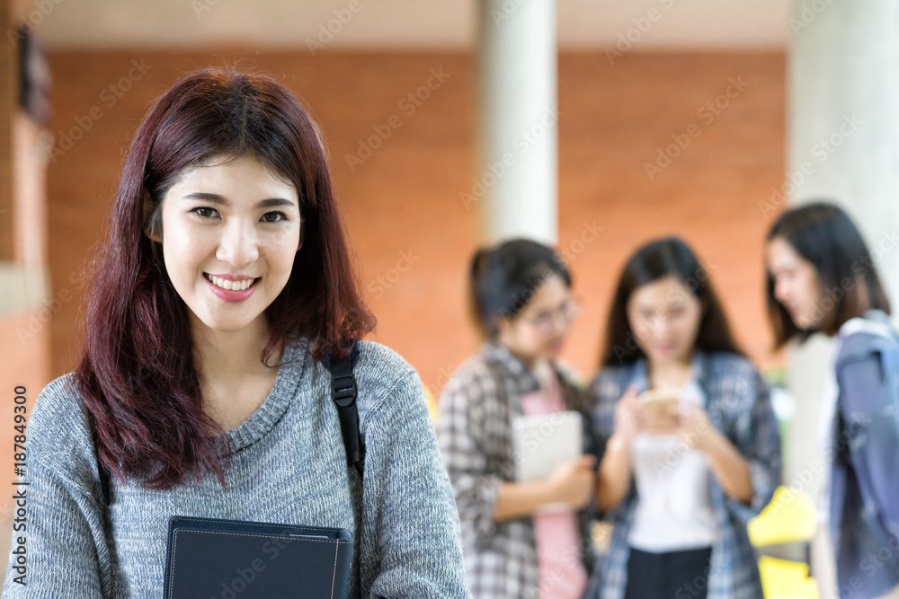 Portrait smilling and happy asian college student at campus with group of student talking background. Education at university concept. Portrait smilling and happy asian college student at campus with group of student talking background. Education at university concept.