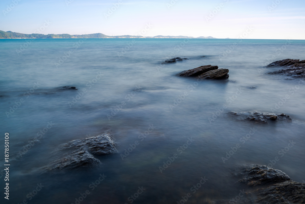 Sea wave impact with rock streak like a boil water with clear sky, Khao Leam Ya National Park at Rayong of Thailand (Long Exposure Technique photograph)