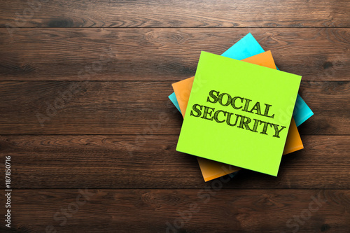 Social Security, the phrase is written on multi-colored stickers, on a brown wooden background. social concept, strategy, plan, planning. photo