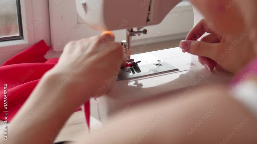 Sewing Machine In Action Woman sews on the modern sewing machine. Sewing machine sews close up ...