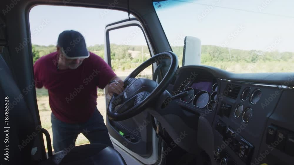 Truck driver getting in an starting up truck. Fully released for commercial use. Truck driver getting in an starting up truck. Fully released for commercial use.