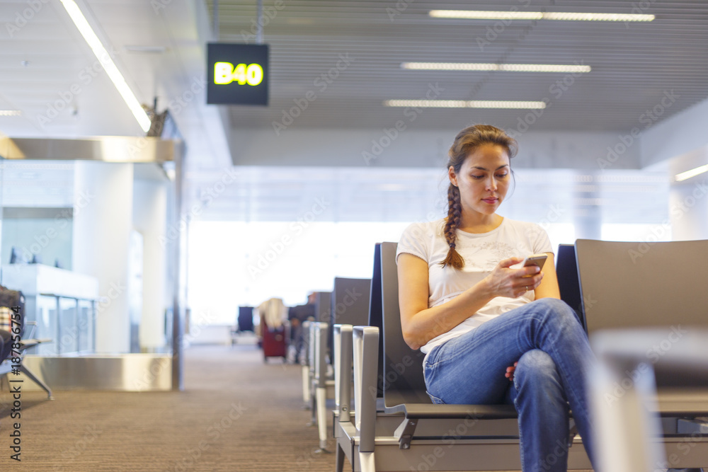 An asian woman is using smartphone in an airport An asian woman is using smartphone in an airport