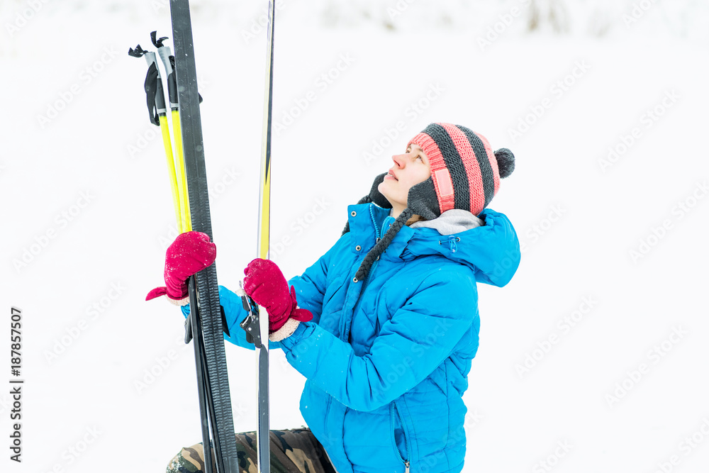 young caucasian woman checking her ski equipment outside in winter young caucasian woman checking her ski equipment outside in winter