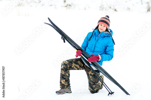 happy young woman outside with a pair of skis