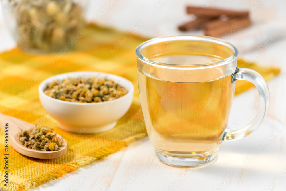 Cup of chamomile tea with dry chamomile flowers on white wooden background. Cup of chamomile tea with dry chamomile flowers on white wooden background.