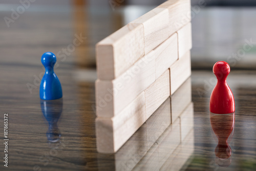 Red And Blue Figurine Paw Separated By Wooden Blocks photo