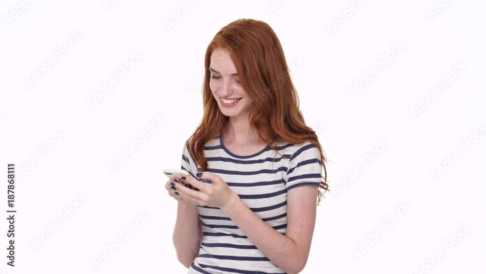 Pretty young cheerful redhead lady isolated over white wall background chatting by mobile phone
Pretty young cheerful redhead lady isolated over white wall background chatting by mobile phone