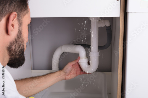 Man Looking At Sink Pipe Leakage