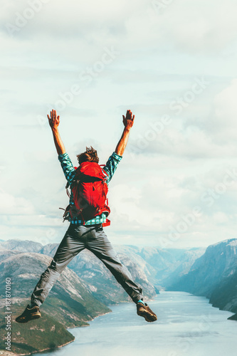 Happy Man extreme jumping Travel Lifestyle adventure concept active summer vacations with backpack outdoor success euphoria emotions in Norway above Lysefjord cliff