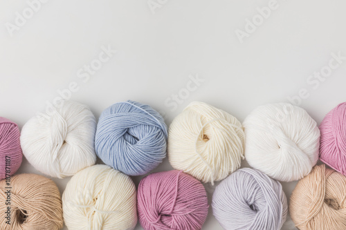 top view of colored yarn balls in a row isolated on white background