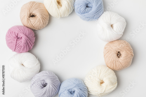 Fotografija top view of circle of colored yarn balls on white background