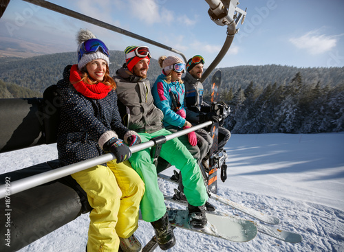Skiers in ski lift over ski terrain