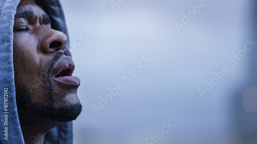Hooded male athlete sweating as he gets his breath back after a workout photo