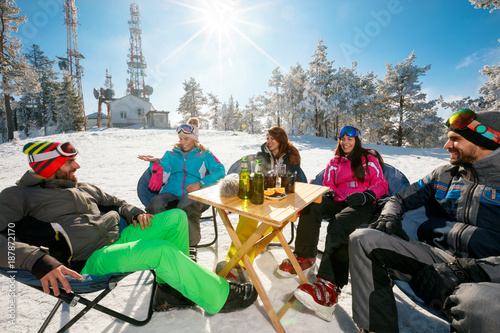 Skiing, winter fun - friends enjoying on hot drink at ski resort