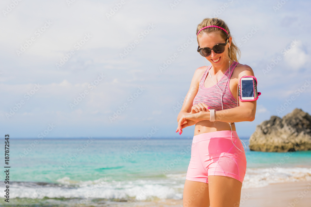 Woman using wearable tech while exercising outdoors Woman using wearable tech while exercising outdoors