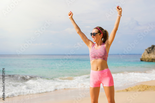 Fotografie Fit woman on the beach feeling excited