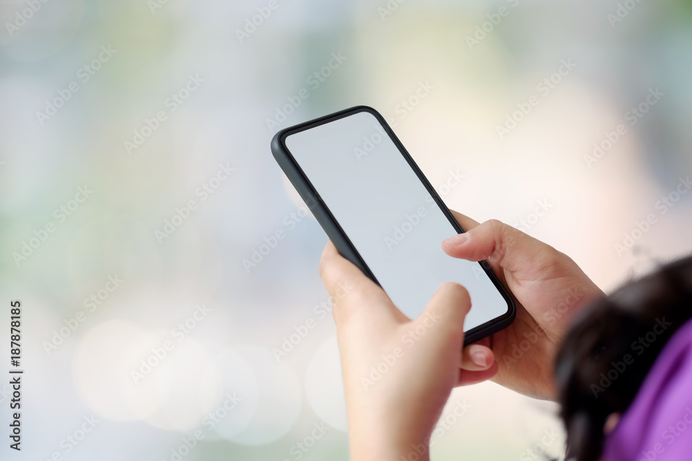 Close up of woman with smartphones with blurred background. Communication and Technology Concept.