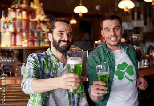 male friends drinking green beer at bar or pub