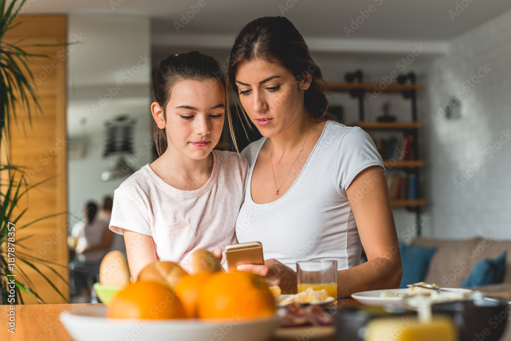 Mother and daughter looking at mobile phone