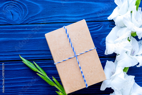 Preparing to celebration. Box in kraft paper near flower gladiol photo