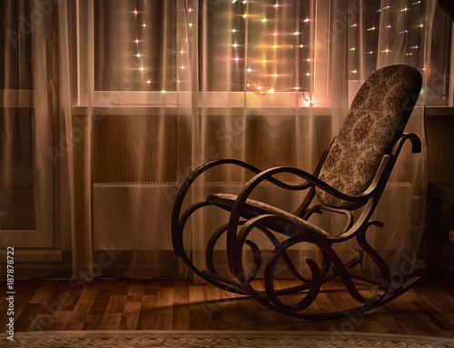 Foto A rocking chair stands by the window in the evening light.