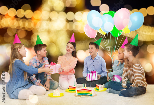 happy children giving presents at birthday party