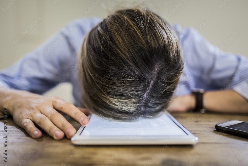 Close up of woman lying on tablet at desk Close up of woman lying on tablet at desk