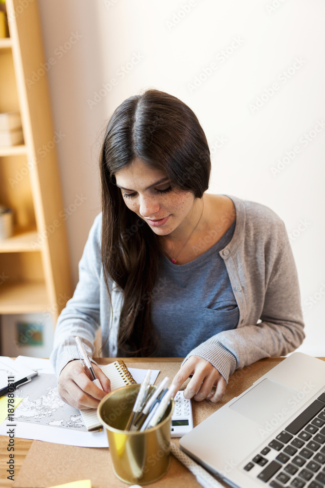 Businesswoman taking notes on table in office Businesswoman taking notes on table in office