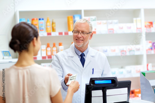 customer giving money to pharmacist at drugstore