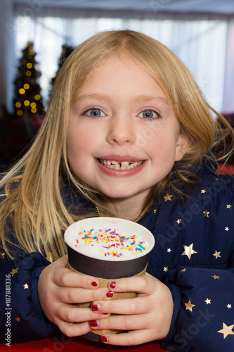 adorable young girl drinking hot chocolate on cold day 